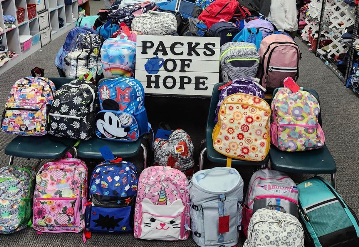packs of hope sign with many cute backpacks